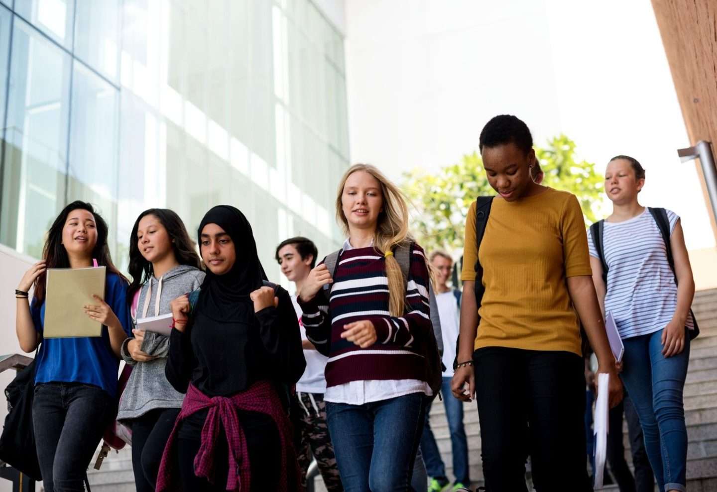 A diverse group of students heading down the stairs of a school displaying education equity of students from any background.